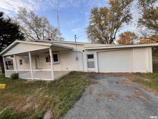 single story home featuring a garage and a porch