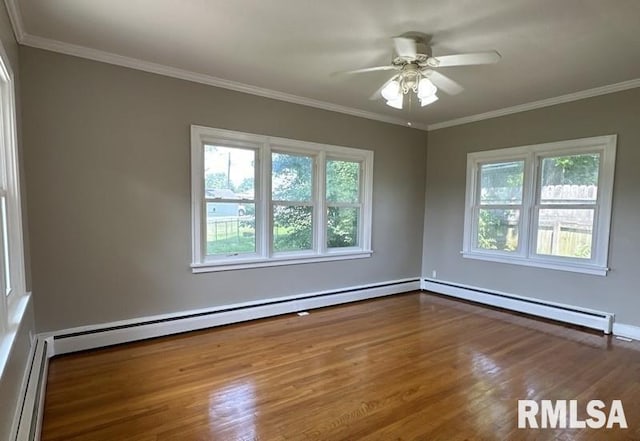 spare room with ceiling fan, a healthy amount of sunlight, baseboard heating, and wood-type flooring