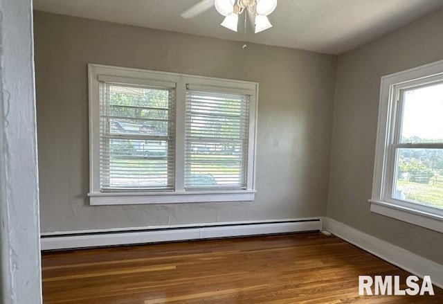 empty room featuring hardwood / wood-style flooring, baseboard heating, and ceiling fan