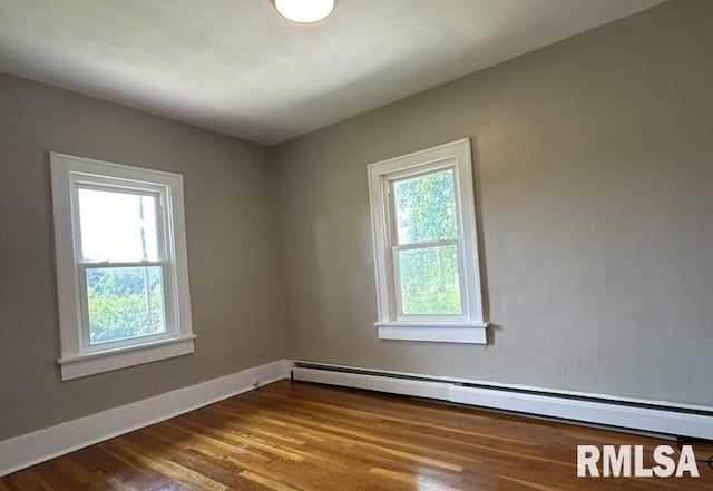 unfurnished room with hardwood / wood-style flooring and a baseboard radiator