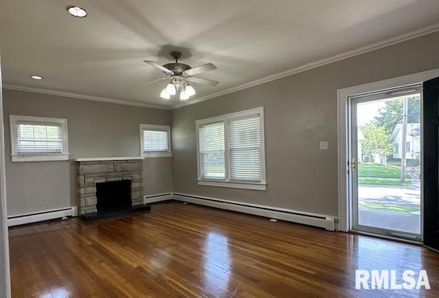 unfurnished living room featuring a wealth of natural light, baseboard heating, and dark hardwood / wood-style floors