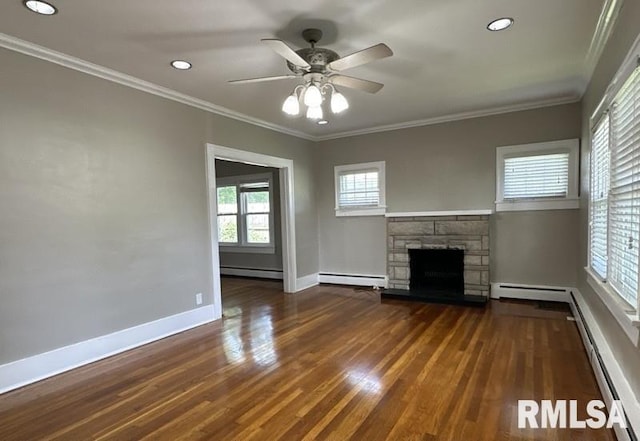 unfurnished living room with ceiling fan, a stone fireplace, ornamental molding, and dark hardwood / wood-style flooring