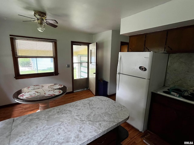 kitchen featuring dark hardwood / wood-style flooring, white fridge, and ceiling fan