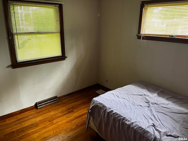 bedroom with dark hardwood / wood-style flooring