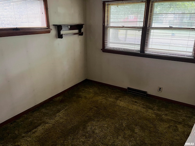 unfurnished room with dark colored carpet