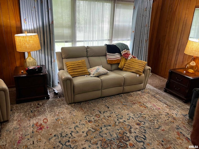 carpeted living room featuring wood walls