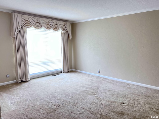 unfurnished room featuring baseboards, visible vents, a textured wall, ornamental molding, and carpet flooring