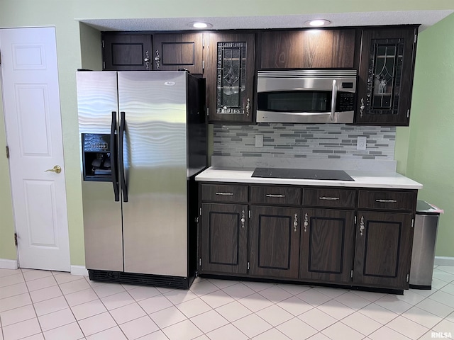 kitchen with light tile patterned floors, appliances with stainless steel finishes, dark brown cabinets, and backsplash