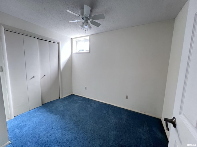 unfurnished bedroom with dark colored carpet, a closet, ceiling fan, and a textured ceiling