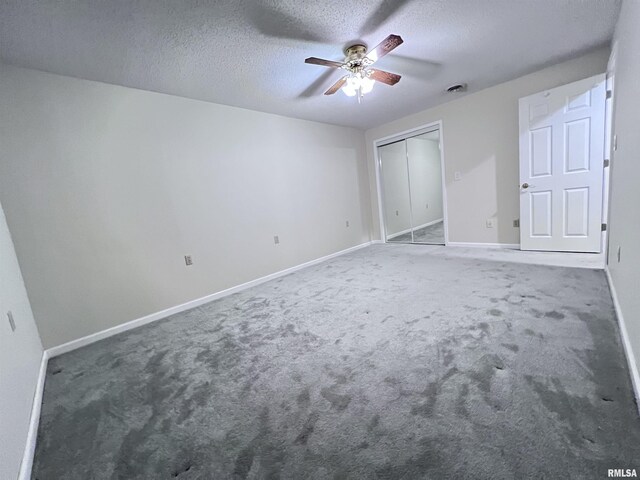 unfurnished bedroom featuring a textured ceiling, ceiling fan, carpet flooring, baseboards, and a closet