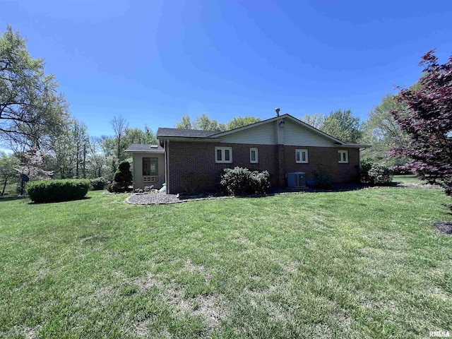 view of home's exterior featuring a yard, brick siding, and central air condition unit