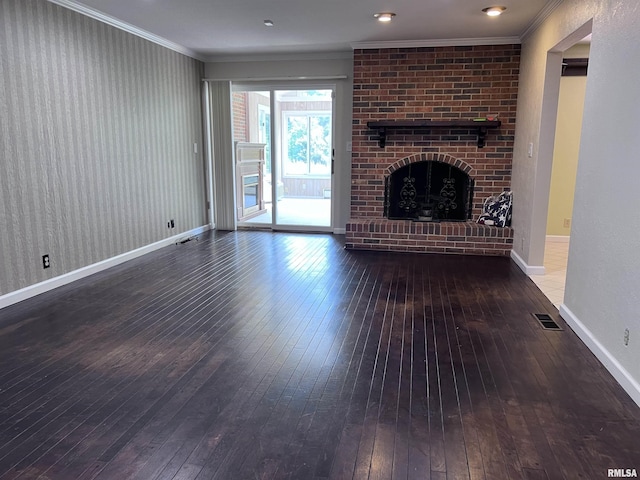 unfurnished living room featuring ornamental molding, wood-type flooring, visible vents, and a brick fireplace