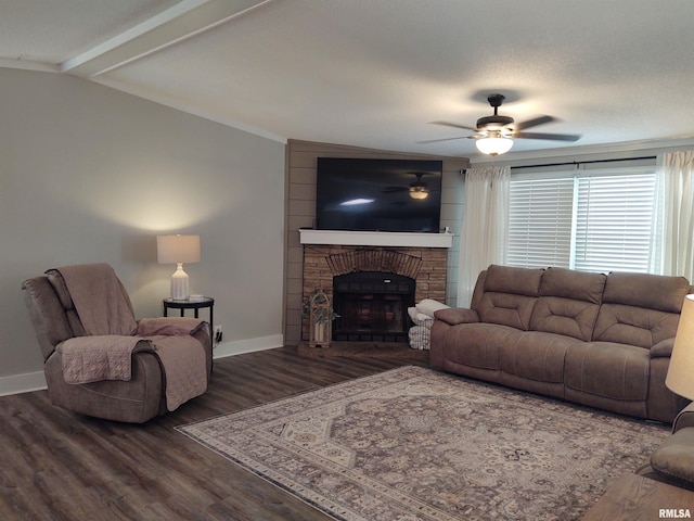 living room featuring ceiling fan, dark hardwood / wood-style floors, vaulted ceiling, and a stone fireplace