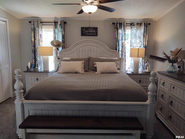 carpeted bedroom featuring ceiling fan, a textured ceiling, a closet, and multiple windows