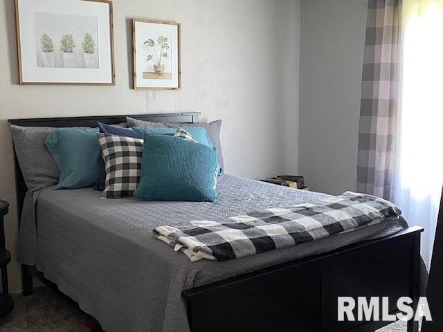 bedroom with carpet floors and multiple windows