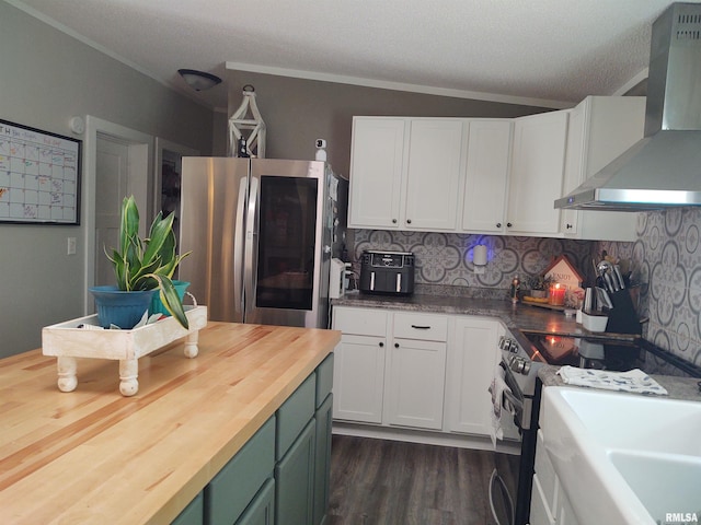 kitchen with dark hardwood / wood-style floors, stainless steel refrigerator, tasteful backsplash, wall chimney range hood, and white cabinets