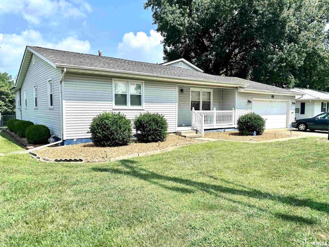 single story home with a porch, a front yard, and a garage