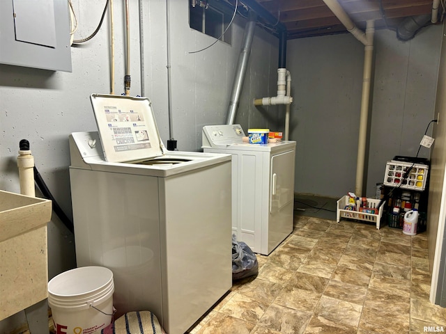 clothes washing area featuring electric panel, sink, and washing machine and dryer