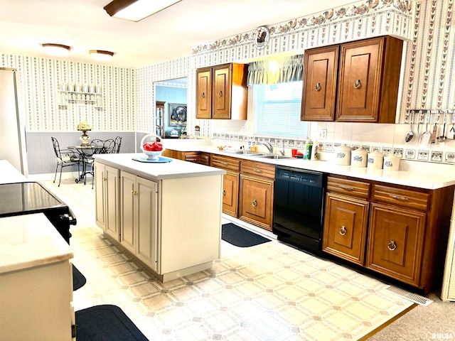 kitchen with black dishwasher, sink, backsplash, and a kitchen island