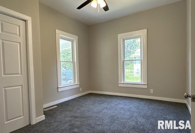 carpeted spare room featuring ceiling fan