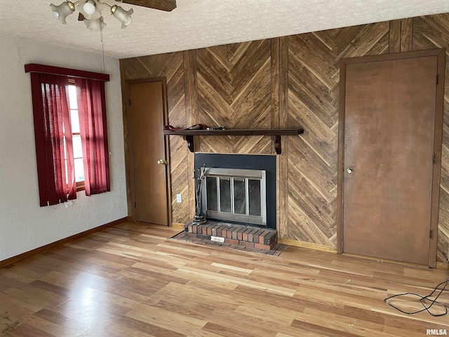 unfurnished living room with a textured ceiling, hardwood / wood-style flooring, and wooden walls