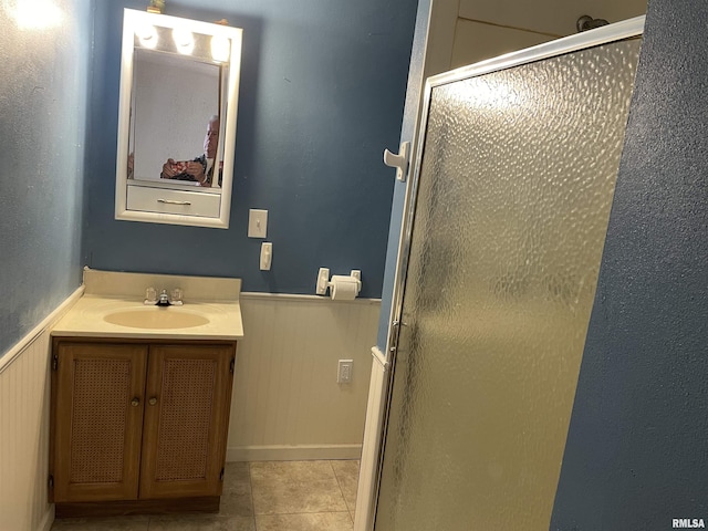 bathroom featuring wooden walls, tile patterned flooring, vanity, and an enclosed shower