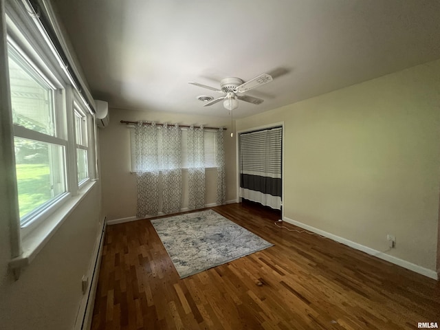 unfurnished bedroom with ceiling fan, dark hardwood / wood-style flooring, a wall mounted air conditioner, and a baseboard radiator