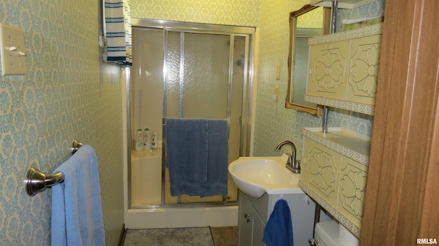 bathroom featuring tile patterned flooring, toilet, an enclosed shower, and vanity