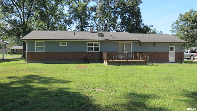 rear view of property with a yard and a wooden deck