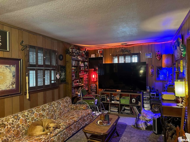 living room with carpet, wooden walls, and a textured ceiling