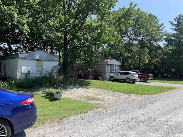 manufactured / mobile home featuring driveway and a front lawn