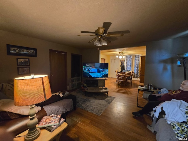 living room with wood-type flooring, a textured ceiling, and ceiling fan