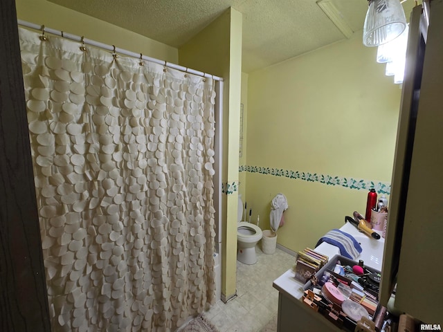 bathroom with a textured ceiling, tile patterned floors, walk in shower, toilet, and vanity