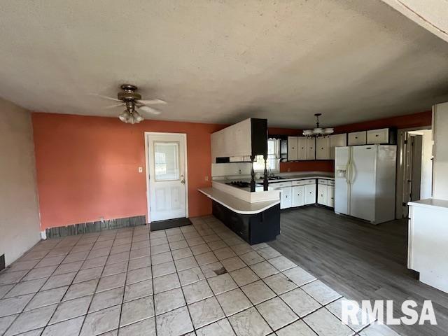 kitchen featuring kitchen peninsula, light wood-type flooring, ceiling fan, white refrigerator with ice dispenser, and white cabinetry