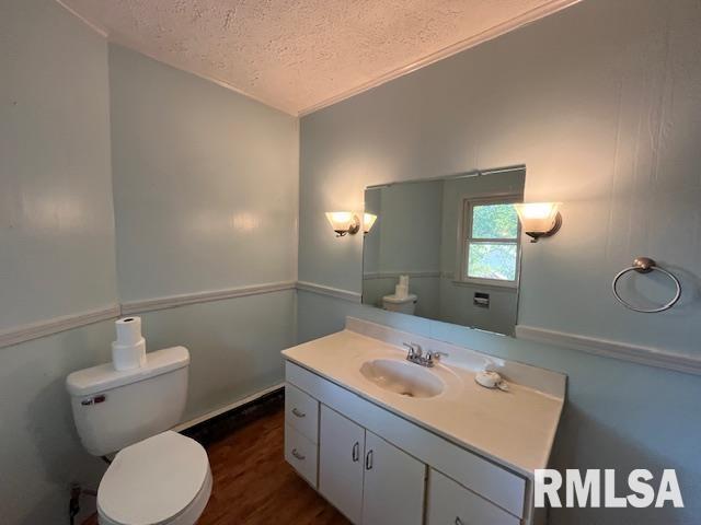 bathroom featuring toilet, vanity, a textured ceiling, and hardwood / wood-style flooring