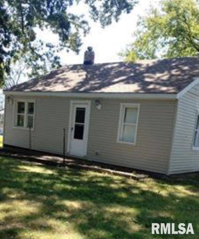 rear view of house featuring a lawn