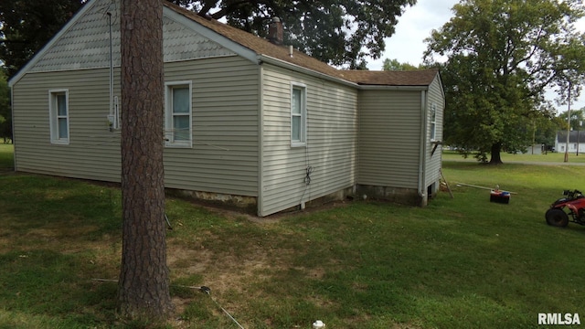 view of home's exterior featuring a yard and a chimney