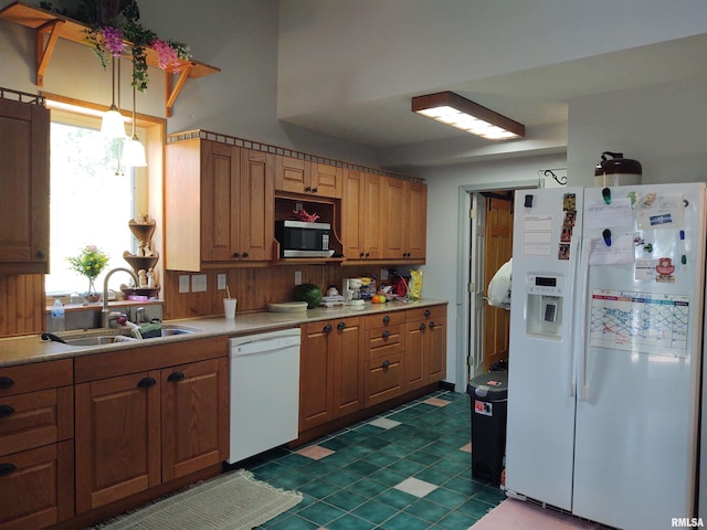 kitchen featuring decorative light fixtures, white appliances, tile patterned flooring, and sink