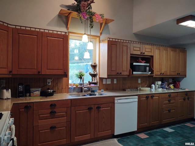 kitchen with decorative light fixtures, white appliances, dark tile patterned floors, and sink