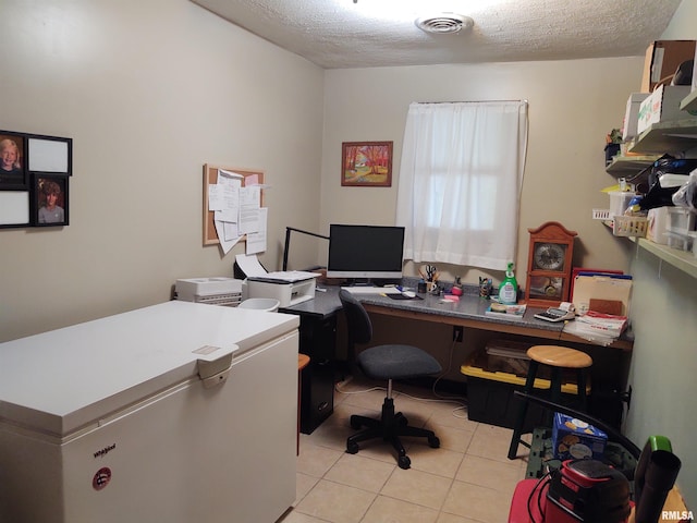 office area with visible vents, a textured ceiling, and light tile patterned floors