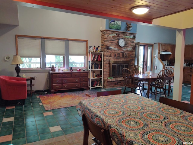 tiled dining area featuring wooden ceiling and a brick fireplace