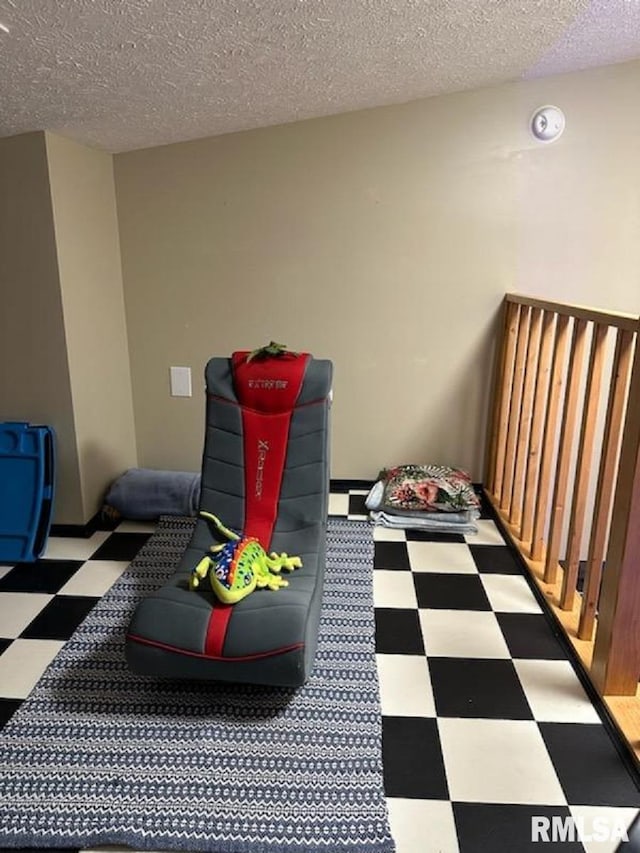 playroom with a textured ceiling and tile patterned floors