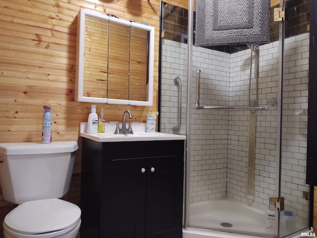 bathroom featuring wood walls, toilet, a shower with door, and vanity