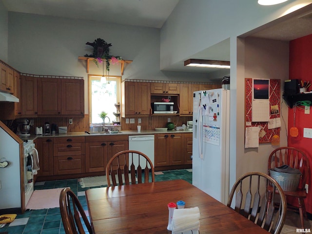 kitchen featuring white appliances, sink, and tile patterned floors