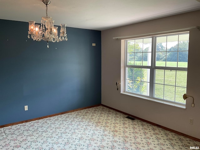 spare room featuring a notable chandelier