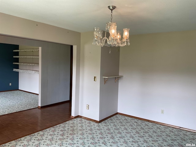 spare room featuring carpet and an inviting chandelier