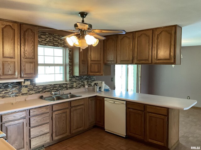 kitchen featuring tasteful backsplash, kitchen peninsula, sink, white dishwasher, and ceiling fan