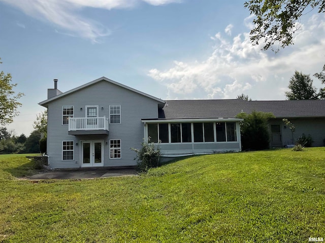 back of house with a patio area, a balcony, french doors, a yard, and a sunroom