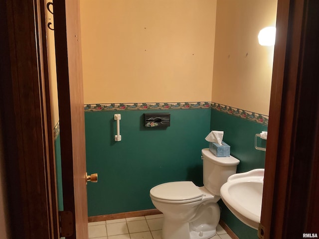 bathroom featuring toilet, sink, and tile patterned flooring