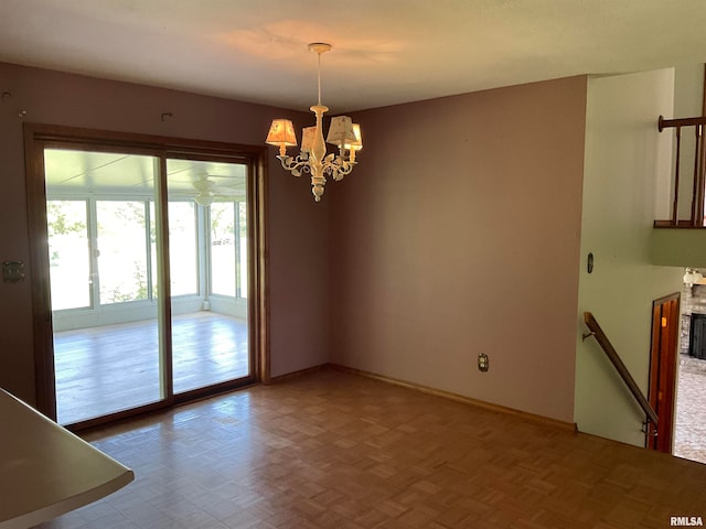 spare room featuring parquet floors and a chandelier